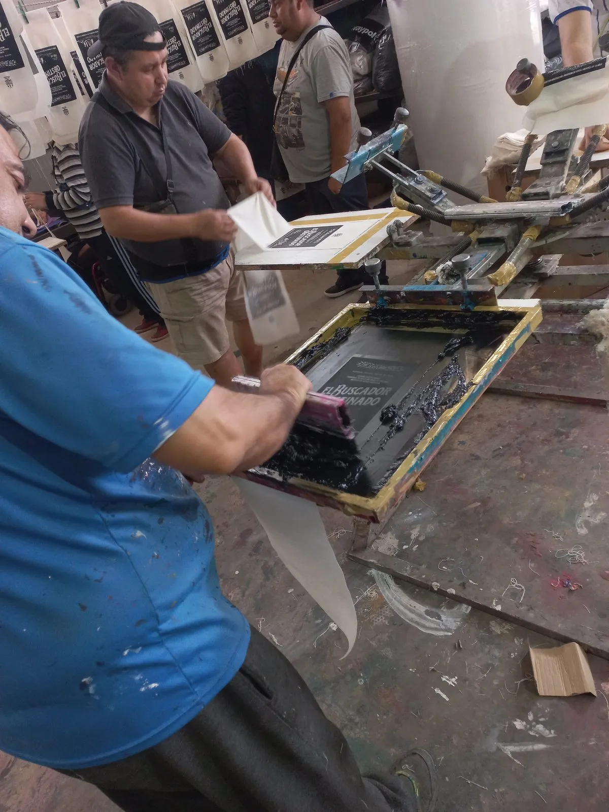 Trabajador pasando la rasqueta sobre el pulpo de serigrafía en el taller