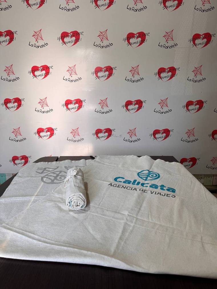 Dos lonas playeras de algodón crudo con logos estampados, una enrollada